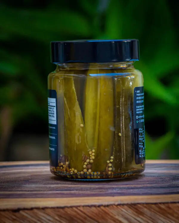 Detalhe das fatias de Picles Jais Handmade, mostrando a espessura e as sementes de mostarda no fundo.