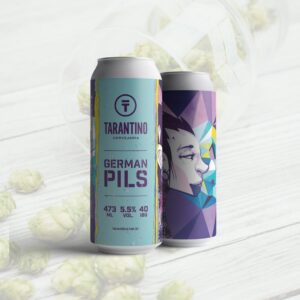 Duas latas da Cerveja German Pils da Cervejaria Tarantino, mostrando o rótulo azul com a arte de um rosto em estilo geométrico.