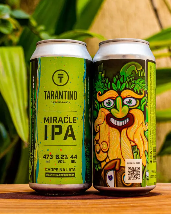 Duas latas da Cerveja Miracle IPA da Cervejaria Tarantino em uma mesa de madeira, mostrando a arte do rótulo e a marca.