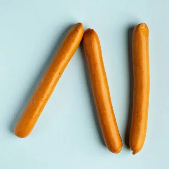 Três salsichas Frankfurter artesanais FA Famiglia Artigianale de cor dourada e textura lisa sobre fundo azul claro. Três salsichas Frankfurter artesanais FA Famiglia Artigianale de cor dourada e textura lisa sobre fundo azul claro.