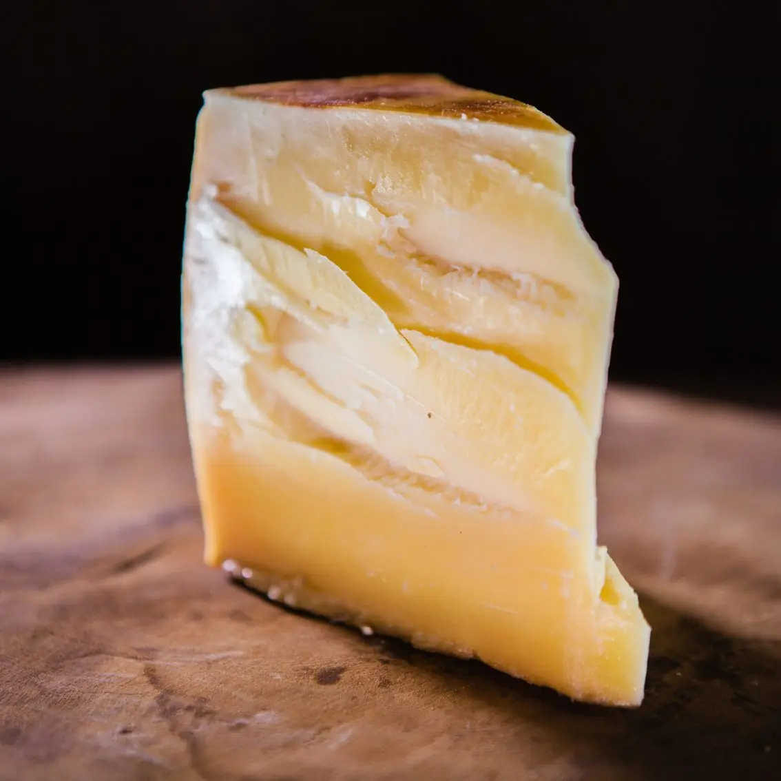 Fatia de queijo Tulha com massa densa e amarelada
