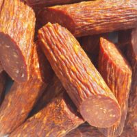 Close-up de fatias de salame espanhol artesanal com cor avermelhada intensa devido à páprica