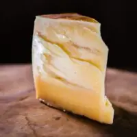 Cunha do queijo duro Tulha Fazenda Atalaia exibindo ranhuras de cristais de tirosina na massa clara.