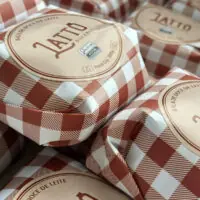 Bala de doce de leite puxa-puxa Latto Doceria em embalagem de papel quadriculado tradicional.