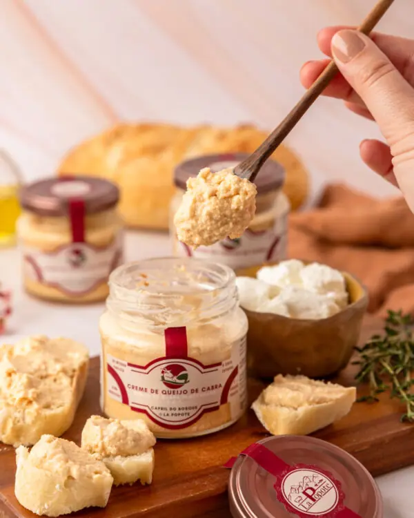 Creme de Queijo de Cabra La Popote sendo servido com espátula de madeira sobre tábua de queijos artesanais com pão e tomilho fresco Creme de Queijo de Cabra La Popote sendo servido com espátula de madeira sobre tábua de queijos artesanais com pão e tomilho fresco