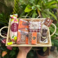 Cesta Doçuras de Páscoa com Favo MBee, Goiabada Jatiboca e Chocolate Mestiço em caixa de madeira rústica.