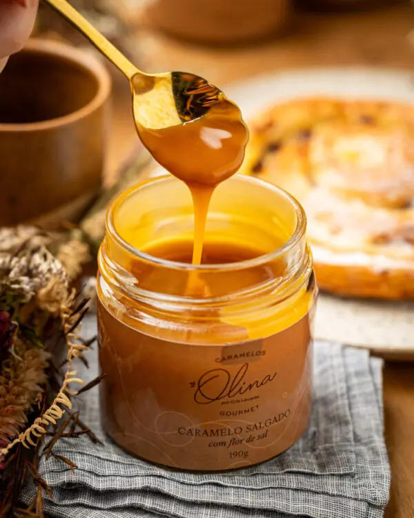 Foco na calda fluída brilhante e espessa na cor âmbar macio sendo servida por fina colher dourada. Foco na calda fluída brilhante e espessa na cor âmbar macio sendo servida por fina colher dourada.