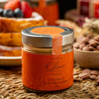 Pote de Caramelo de Chocolate com Laranja Olina em mesa de café com rabanadas e frutas vermelhas.