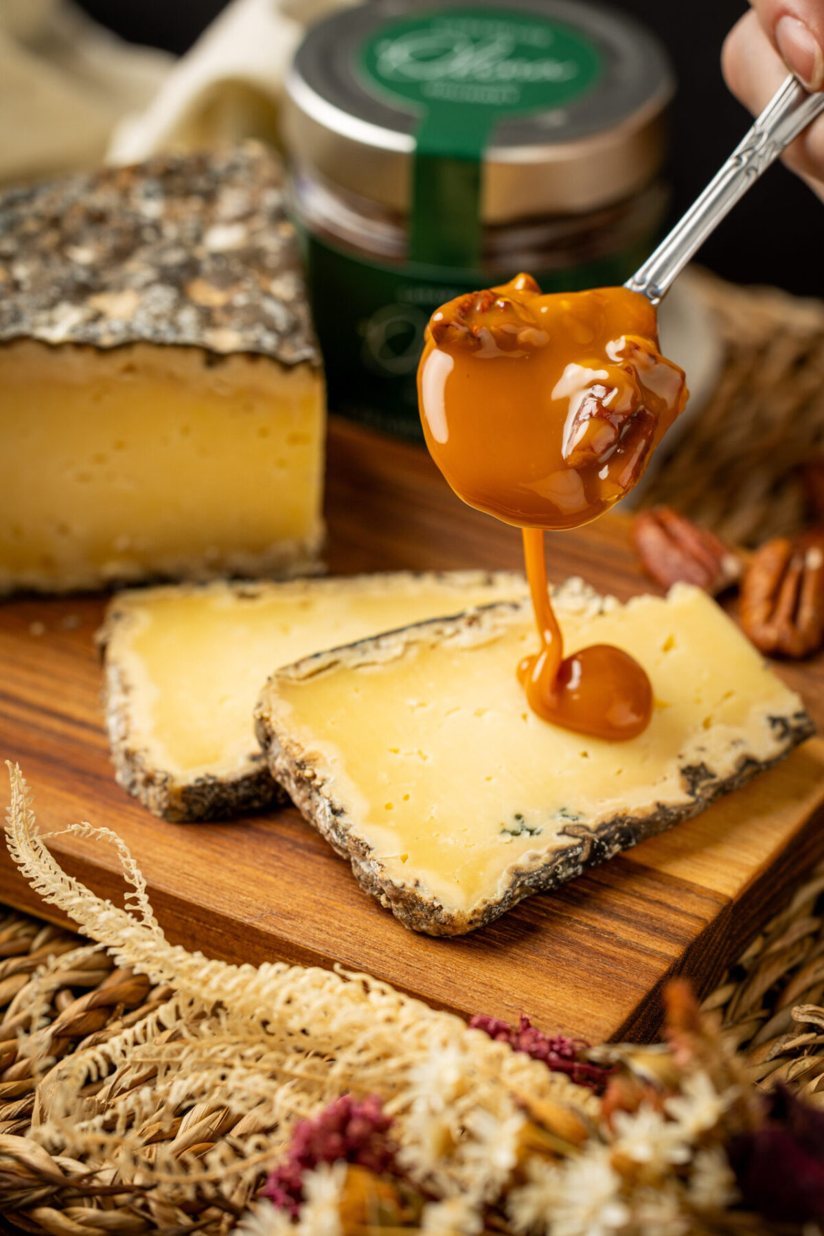 inâmica da Calda de caramelo rústico e doce amadeirada despejada graciosamente por cima das fatias amarelas pontilhadas do puro queijo curado, servido acima da base tabulada de carne natural rústica.