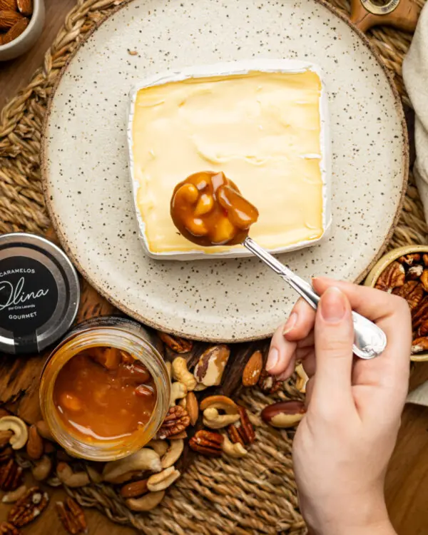 Calda cremosa de caramelo picante e pedaços de nozes caindo devagar sobre fatia rústica de queijo brie macio. Calda cremosa de caramelo picante e pedaços de nozes caindo devagar sobre fatia rústica de queijo brie macio.