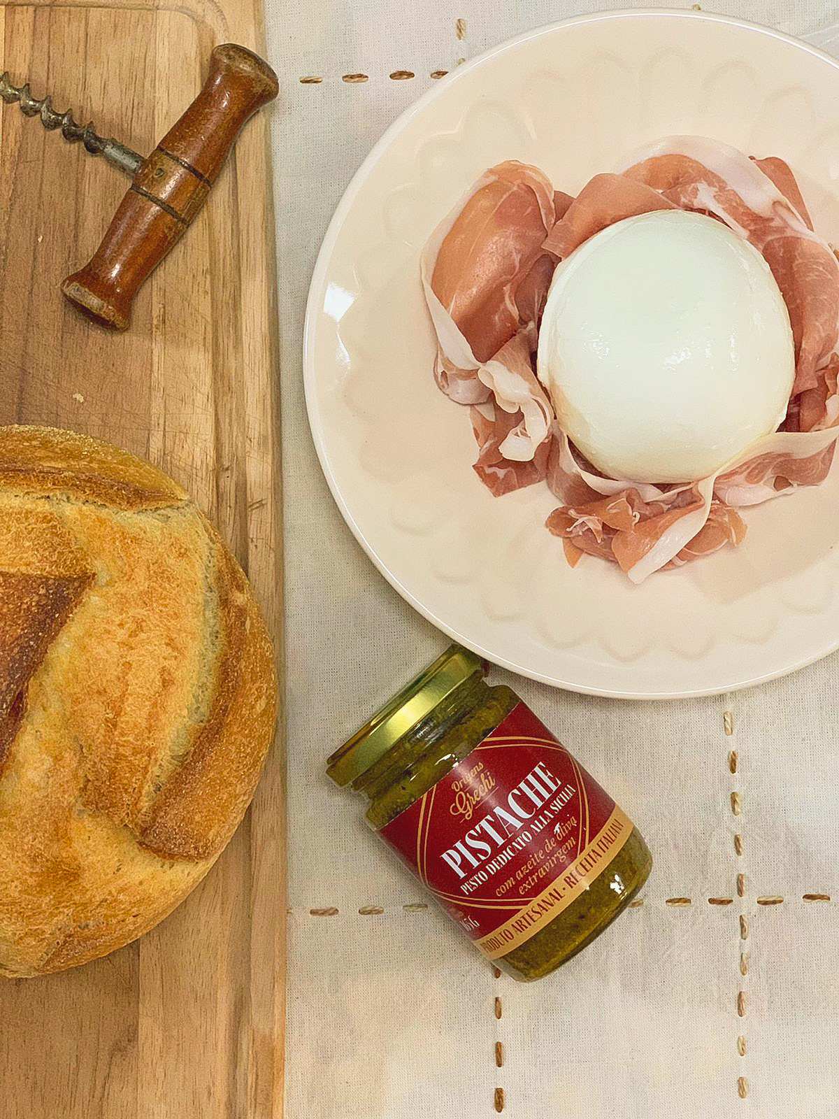 Pesto de Pistache Origens Grechi com burrata sobre presunto cru e pão artesanal — mesa italiana