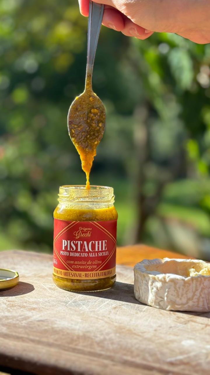 Colher retirando pesto de pistache Origens Grechi do pote mostrando textura cremosa e granulada