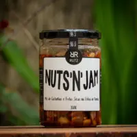 Pote de vidro da geleia de pimenta com castanhas Nuts'n Jam Rutz 350g sobre tábua rústica de madeira.