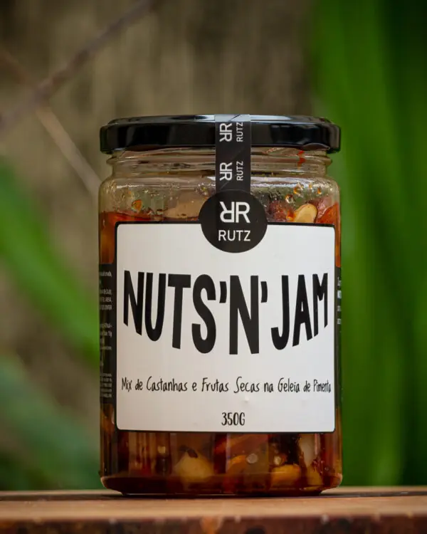 Pote de vidro da geleia de pimenta com castanhas Nuts'n Jam Rutz 350g sobre tábua rústica de madeira.