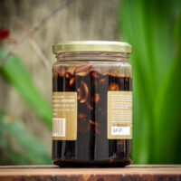Detalhe das amêndoas, avelãs e castanhas inteiras imersas na calda de chocolate meio amargo Rutz.