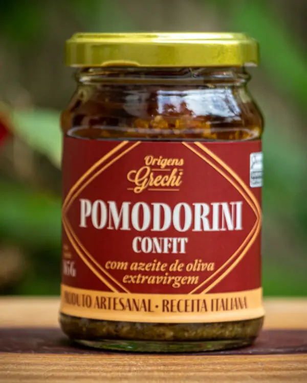 ote de Pomodorini Confit Origens Grechi sobre madeira rústica, evidenciando o tomate cereja confit artesanal.
