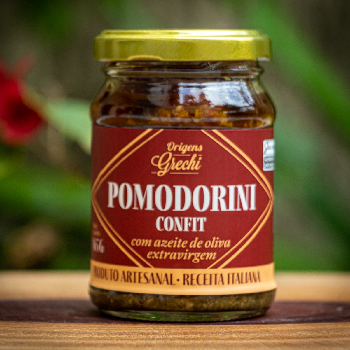 ote de Pomodorini Confit Origens Grechi sobre madeira rústica, evidenciando o tomate cereja confit artesanal.