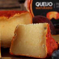 Queijo Jordão Pasta Dura cortado mostrando pasta amarelo-dourada casca urucum vermelha maturado