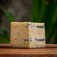 Pedaço Queijo Azul de Pardinho com veios azuis sobre tábua de madeira