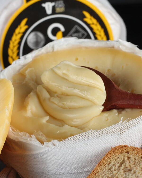 Queijo do Jordão Pasta Mole aberto textura ultra-cremosa colher de madeira com pães artesanais