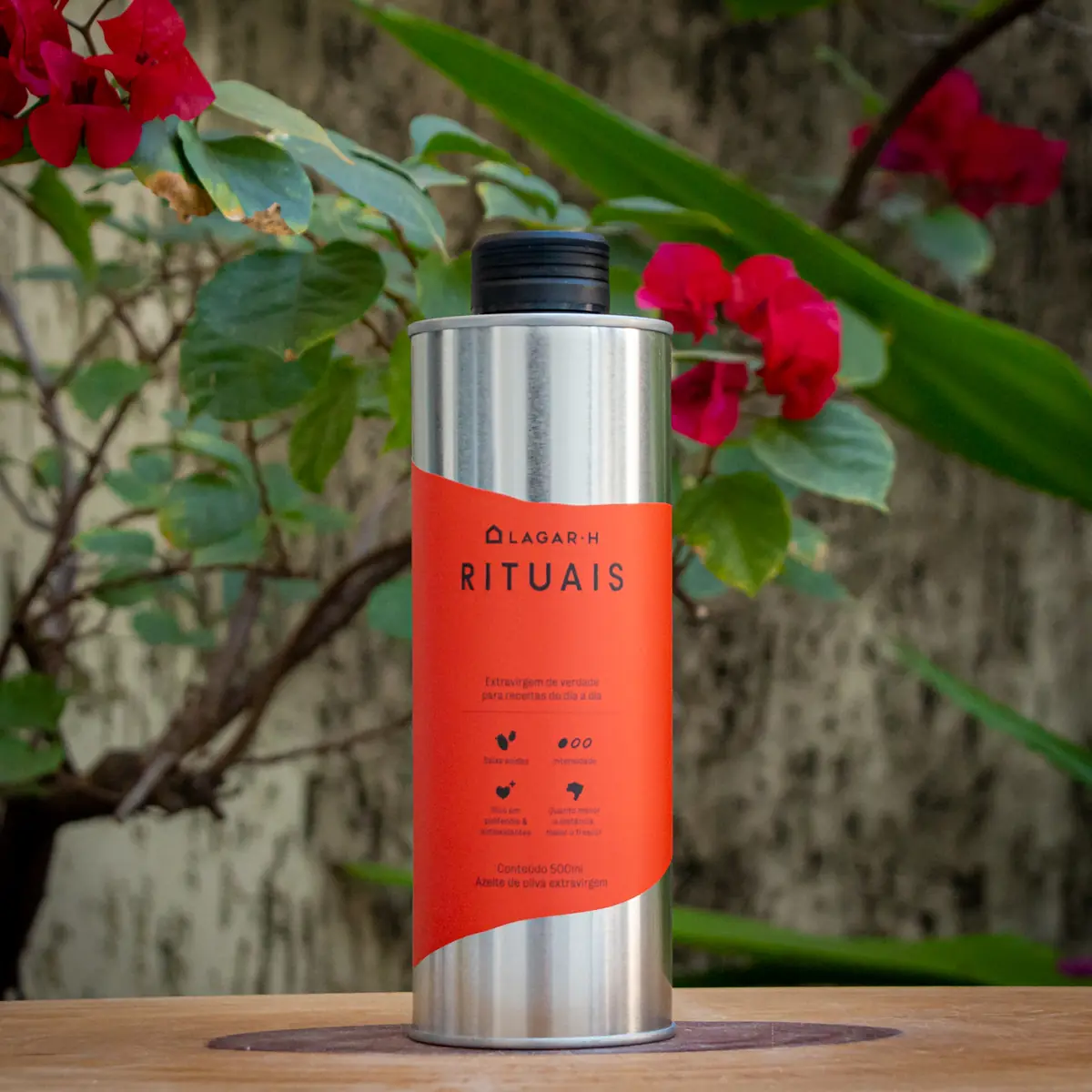 Garrafa de azeite extravirgem Rituais Lagar H 500ml com rótulo laranja sobre mesa de madeira