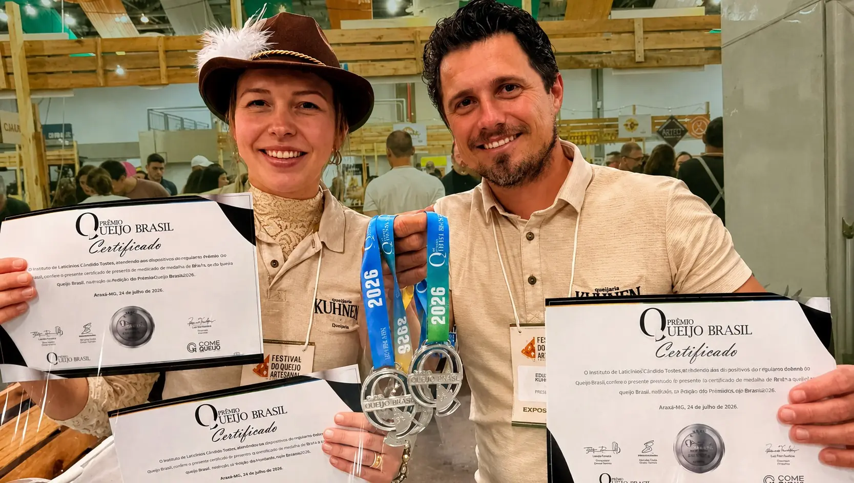 Casal de produtores da Queijaria Kuhnen segurando certificados e medalhas do Prêmio Queijo Brasil 2026